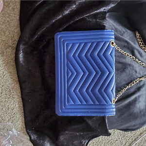 Blue faux leather crossover with a gold chain strap.